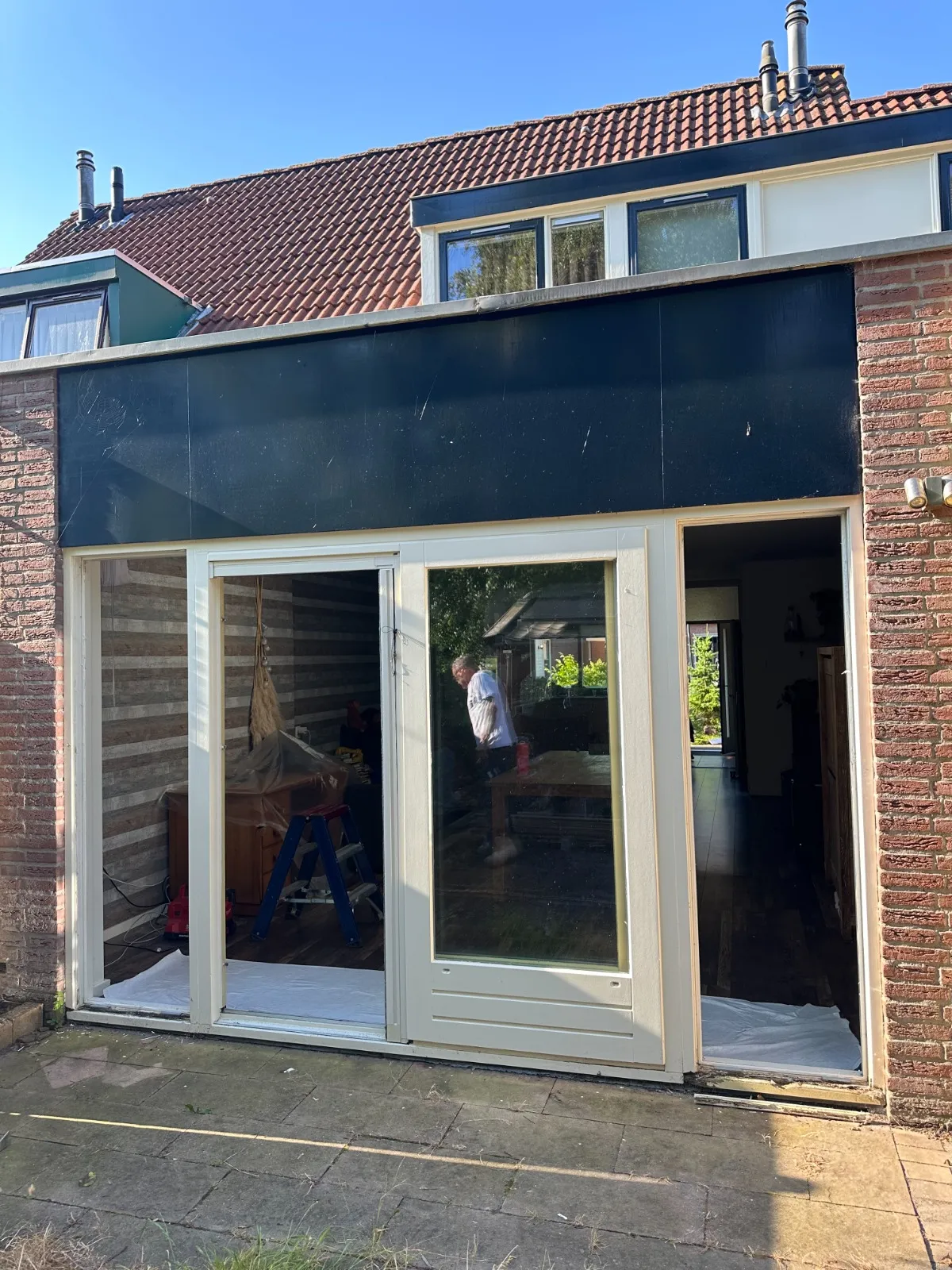 Voor-situatie: oude witte schuifpui met smalle glasvlakken en zware stijlen