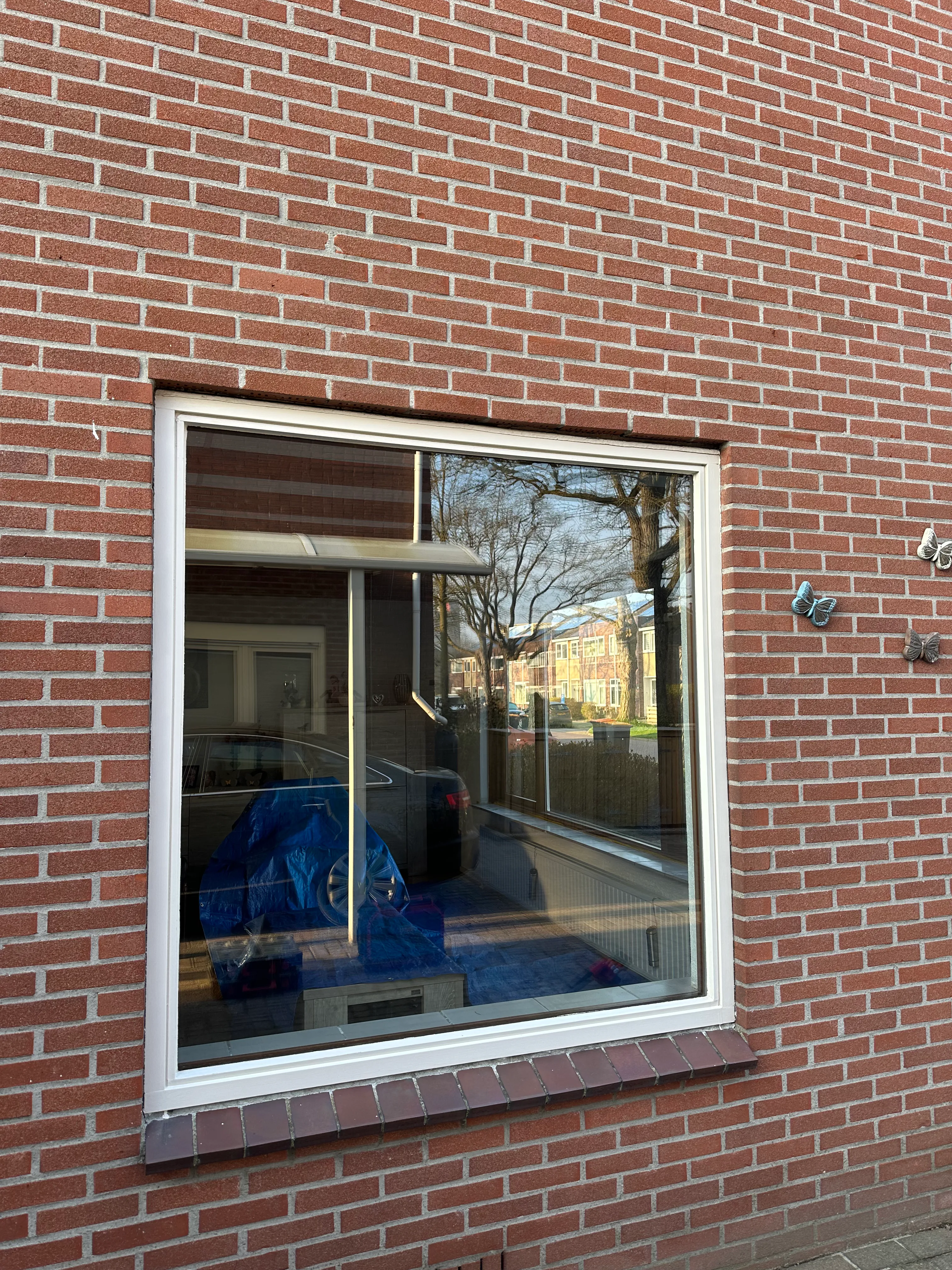 Scherp projectbeeld van nieuw kunststof kozijn in rode achtergevel