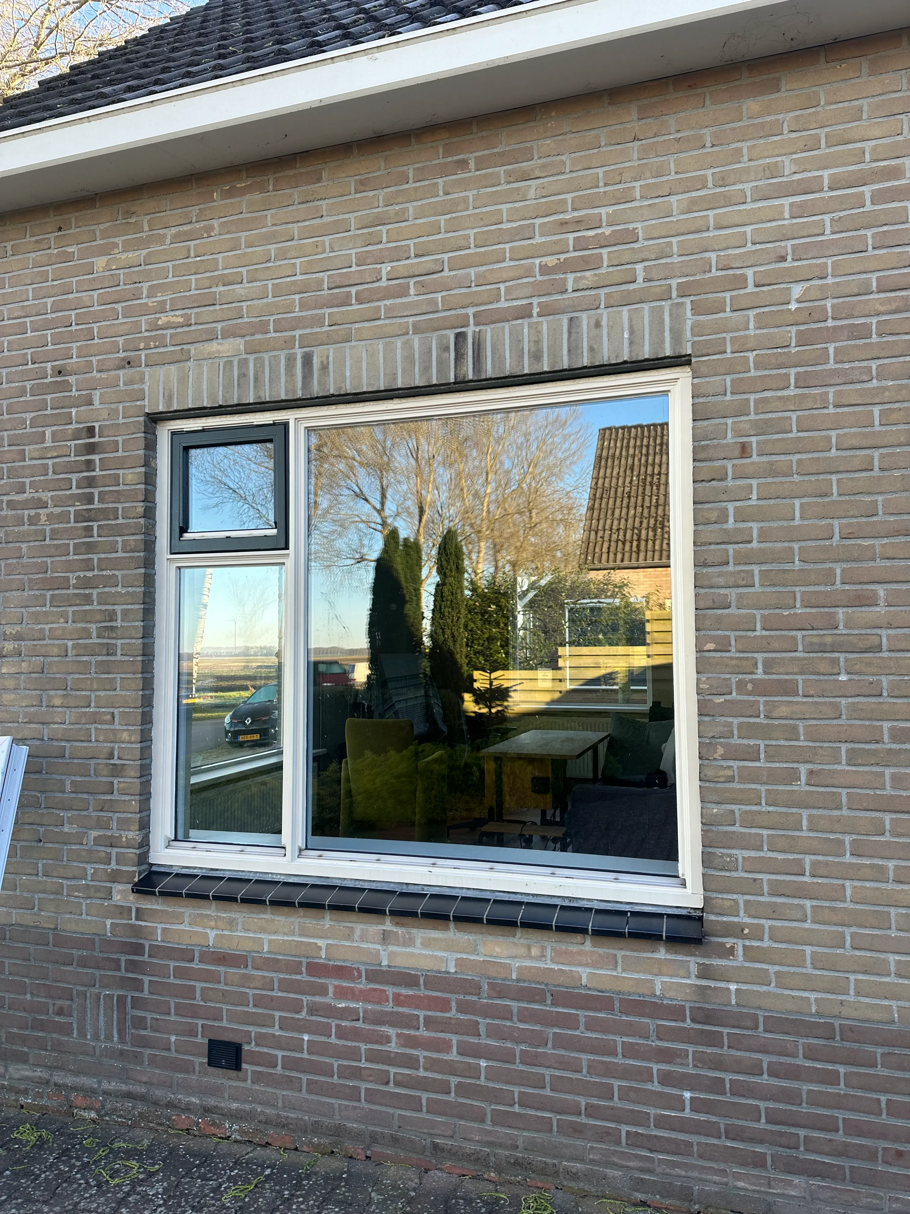 Echte grote glaspartij in kunststof kozijnen aan een lichte gevel